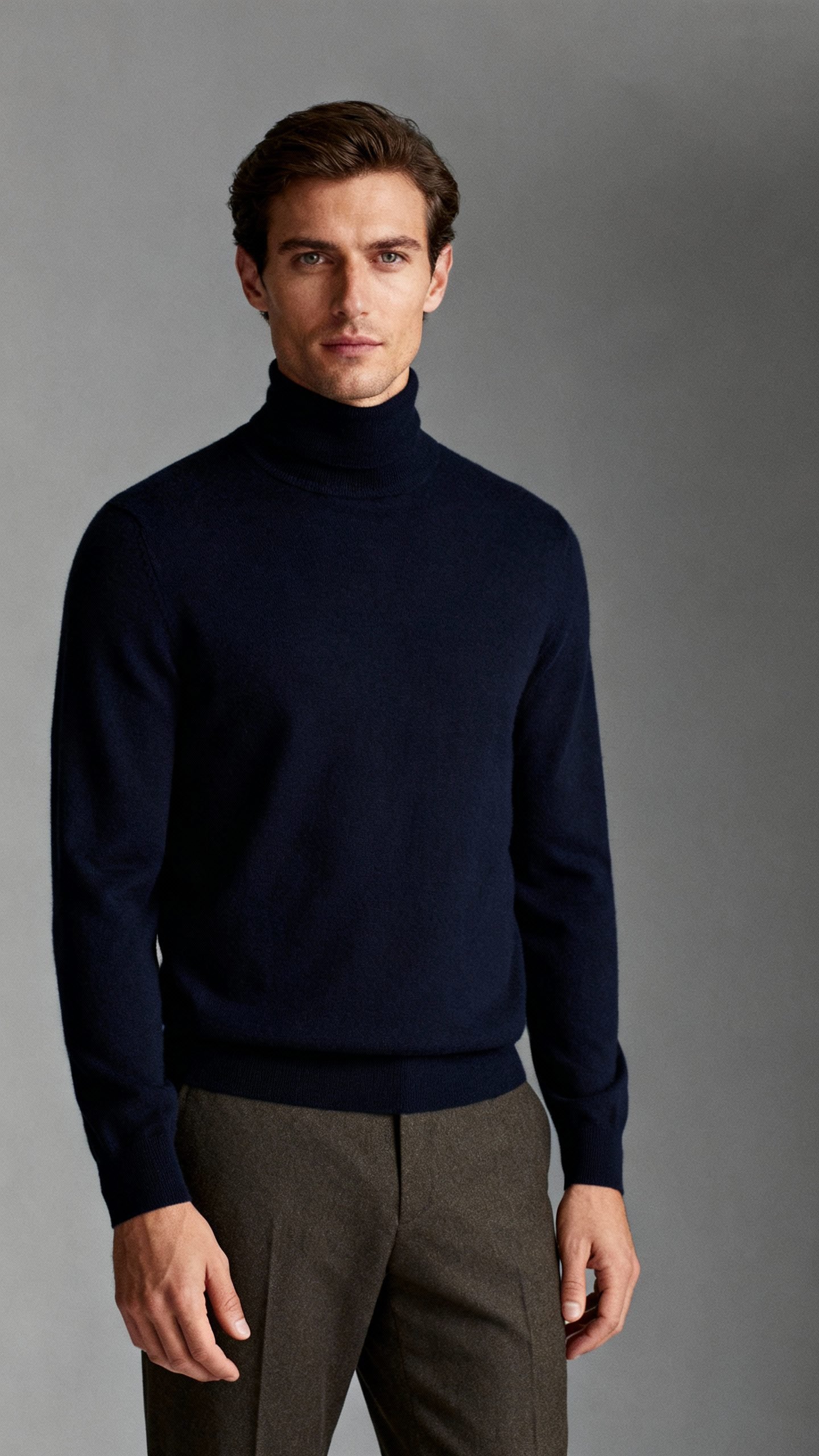 navy merino turtleneck with olive trousers, seamless gray backdrop