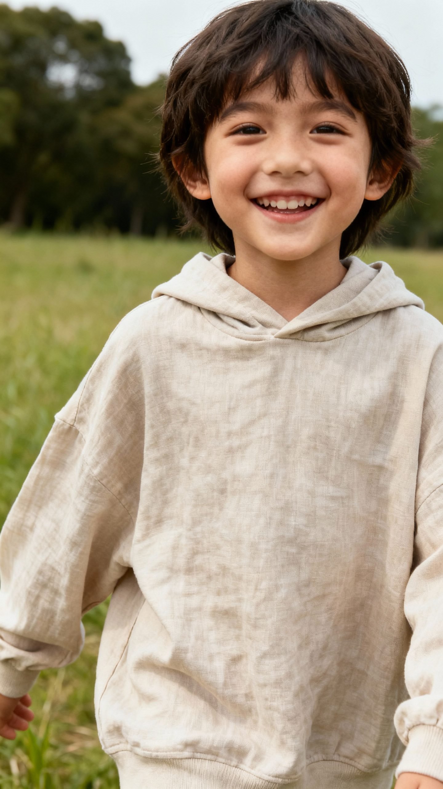 gender-neutral Tencel hoodie, sized up, smiling child outdoors